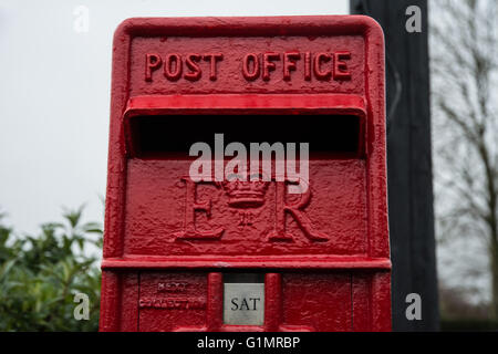 Una chiusura della bocca di un piccolo post box con i tempi di raccolta su di esso. Foto Stock