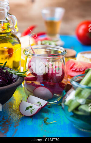 Gli ortaggi biologici sul tavolo rustico. Il Ravanello di fette. Ingredienti per insalata. Cibo vegetariano, concept Foto Stock