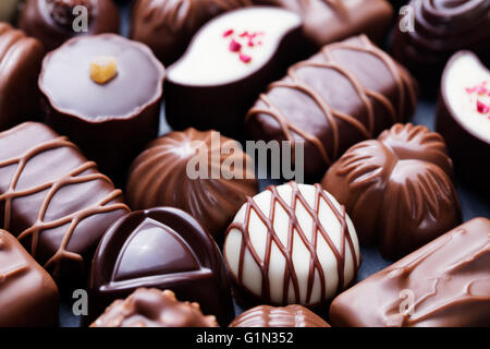 Assortimento di raffinati cioccolatini, bianco, scuro e cioccolato al latte dolci sfondo Foto Stock