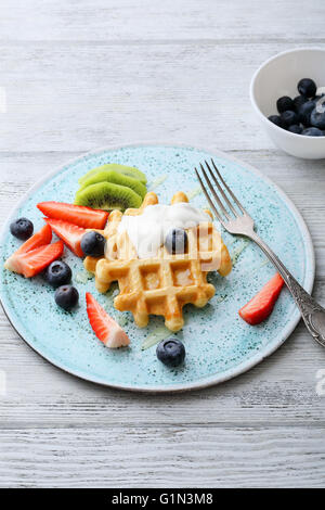 Cialde con crema di latte e frutta sulla piastra Foto Stock