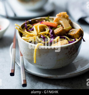 Salsa speziata con le tagliatelle croccanti di tofu & inverno verdure, privi di glutine e vegane. Foto Stock