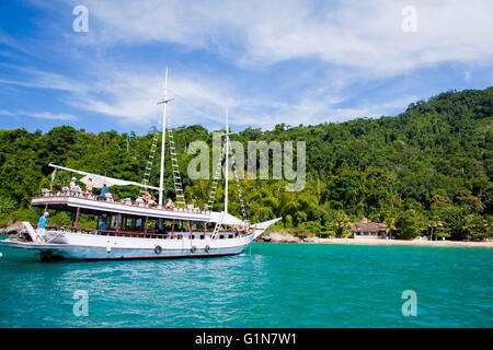 In barca per visite guidate nella parte anteriore del Atlantico intatta vegetazione forestale a Paraty ( o Parati ), una conservata coloniale portoghese brasiliano e città imperiale si trova sulla Costa Verde ( Costa Verde ), un lussureggiante, corridoio verde che corre lungo la costa sud dello stato di Rio de Janeiro, in Brasile. Foto Stock