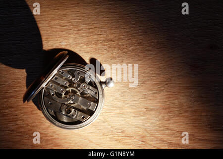 Vintage orologio da tasca posteriore con meccanismo aperto su sfondo di legno Foto Stock