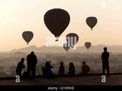 I turisti di scattare fotografie di Mongolfiere sopra i templi di Bagan presso sunrise, Pyathada Paya, Birmania - Myanmar Foto Stock