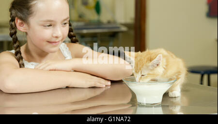 Ritratto di ragazza carina è alla ricerca di un gattino che sta bevendo Foto Stock