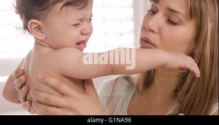 La madre che porta il suo bambino piangere Foto Stock