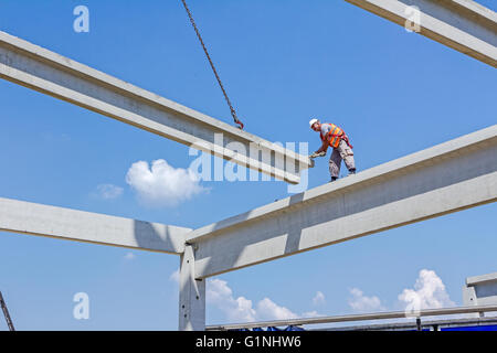 Altezza lavoratore è alto sul telaio di calcestruzzo senza un equipaggiamento di sicurezza adeguato. Foto Stock