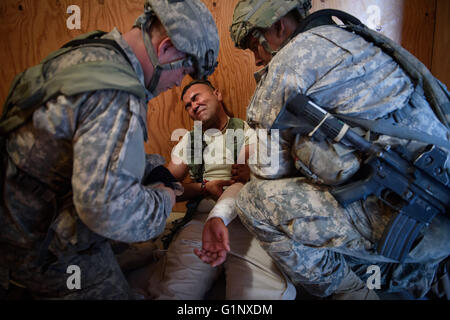 Fort Irwin, California, Stati Uniti d'America. Il 6 agosto, 2015. I paracadutisti con il 2° Brigata Combat Team di fornire cure mediche per un locale nazionale ruolo di giocatore durante il funzionamento Dragon lancia un giunto di ingresso forzato esercizio dimostrando Esercito e Air Force funzionalità, il giovedì, il 6 agosto 2015 in Stati Uniti Esercito nazionale del Centro di formazione a Fort Irwin, ca. Hanno detto i funzionari lo scenario di addestramento non era basato su una qualsiasi potenziale nemico, ma hanno riconosciuto le analogie per il continuo dell'intervento militare russo in Ucraina orientale. ''Nella mia mente anche questo è circa la dissuasione, '' ha detto poi capo dell Esercito di Foto Stock