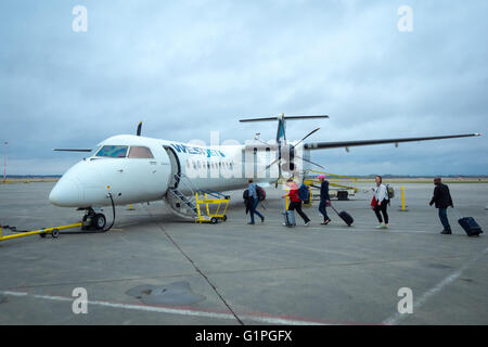 I passeggeri a bordo di un Westjet Encore Bombardier Q400 NextGen aeromobili all'Aeroporto Internazionale di Edmonton, Canada. Foto Stock