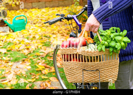Donna con la bicicletta è di trasportare una borsa per la spesa Foto Stock