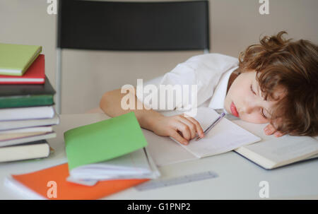 Il ragazzino si è addormentato mentre si fanno i compiti. Foto Stock