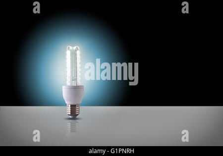 Una spia a LED lampadina sul tavolo bianco con sfondo nero. Vista frontale. Composizione orizzontale Foto Stock