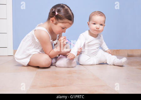 Baby fratello e sorella toddler riproduzione medico con una siringa Foto Stock