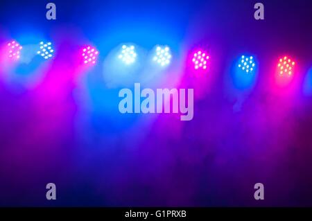 Faretti e apparecchiature di illuminazione con la nebbia sul palco. Illuminazione di concerto come sfondo Foto Stock