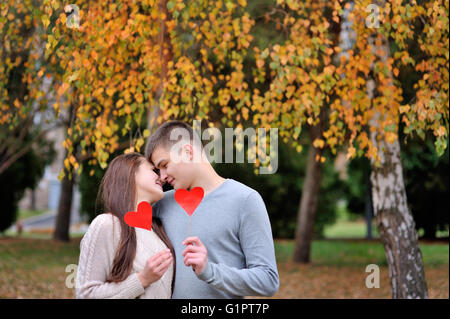 Amare giovane con cuore rosso in autunno park. amore concetto Foto Stock