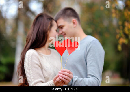 Amare giovane con cuore rosso in autunno park. amore concetto Foto Stock