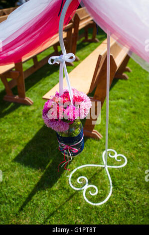 Decorazioni per matrimoni di fiori vicino panche per cerimonia in posizione di parcheggio Foto Stock