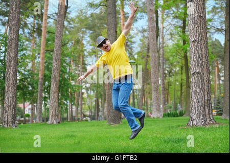 Carino Uomo salto nel parco sulla giornata di sole Foto Stock