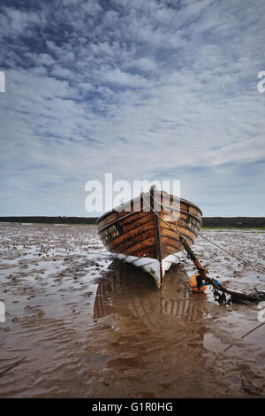 Una barca di solitario con la bassa marea. Robin Hood's Bay. Foto Stock