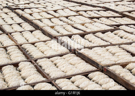 Molti cinesi noodles essiccamento sotto il sole in vassoi di legno Foto Stock