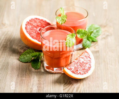Arancione il succo di pompelmo con frutta fresca e foglie di menta. Cibo sano e bevande Foto Stock