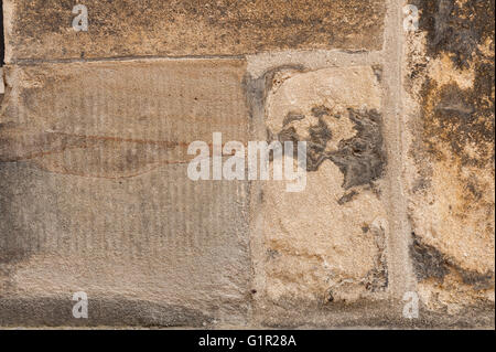 Variazione di superficie di ragstone con stone mason segna boschetti di pigmenti colorati in rock dando l'illusione di facce Foto Stock