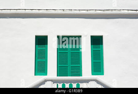 Verde tradizionale di persiane alle finestre sulla facciata dipinta di bianco, Tangeri, Marocco Foto Stock