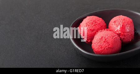 Gelato, ciliegia, lampone, fragola, mirtillo rosso, sorbetto, scoop, in pietra nera di sfondo spazio di copia Foto Stock