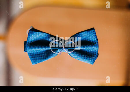 Blue bow tie e gli anelli di nozze su sfondo di legno Foto Stock