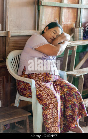 Una donna birmano dormire con la tabella al suo posto di lavoro. Foto Stock