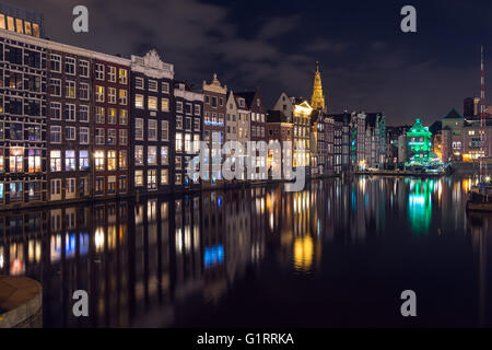 Bella riflessione di Amsterdam's canal case in acqua a notte Foto Stock