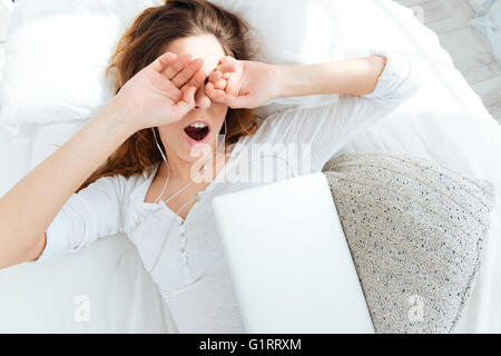 Giovane donna di svegliarvi e strofinando gli occhi a casa Foto Stock