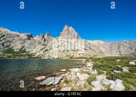 Lago di montagna Lac de Melo, montagne sullo sfondo, Restonica alta valle, Corte, Haute-Corse, Corsica, Francia Foto Stock