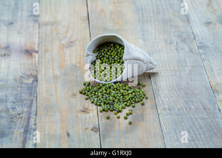 Mung bean nel sacco su vintage di tavole di legno Foto Stock