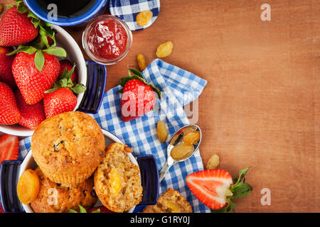 La prima colazione con fatti in casa muffin alla carota, marmellata, caffè e fragole fresche Foto Stock