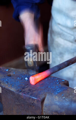 Fabbro di forgiare un Red Hot pezzo di ferro Foto Stock