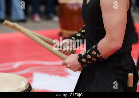 Artista giapponese giocando sui tradizionali tamburi taiko Foto Stock