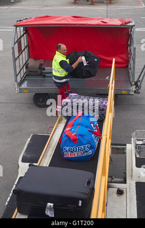 Aeroporto di carico del lavoratore di bagagli su aeromobili all'Aeroporto Stansted di Londra England Regno Unito Regno Unito Foto Stock