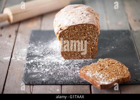 Fresco di soda irlandese pane con oat affettato su ardesia tagliere il fuoco selettivo Foto Stock