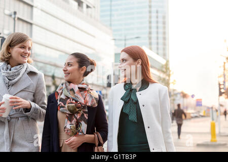 Imprenditrici a piedi con caffè in città Foto Stock