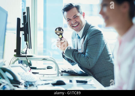 Ritratto di imprenditore entusiasta holding vincitore trofeo a scrivania in ufficio Foto Stock