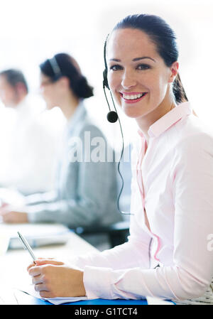 Ritratto di sorridere imprenditrice parlando al telefono con cuffia Foto Stock