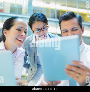 Sorridente la gente di affari con tavoletta digitale in ufficio Foto Stock