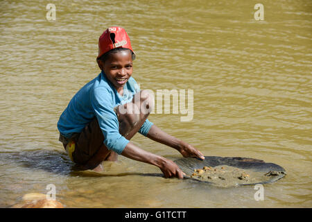 MADAGASCAR, regione Manajary, città Vohilava, piccola scala miniere d'oro, i bambini il panning per oro a fiume ANDRANGARANGA / Madagascar Mananjary, Vohilava, kleingewerblicher Goldabbau, Kinder waschen Gold am Fluss ANDRANGARANGA, Junge CLEMENCE 12 Jahre Foto Stock