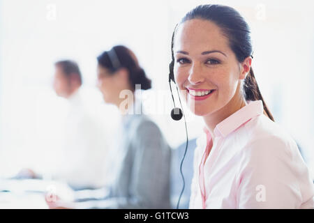 Ritratto di sorridere imprenditrice parlando al telefono con cuffia Foto Stock