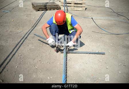 Lavoratori impiombare il filo di controllo per il cavo auto presso il cantiere per la International Garden Show (IGA) di Berlino, Germania, 18 maggio 2916. Molla di avviamento 2017, gondole di cavalcare lungo la 1.5km-lungo percorso ad una altezza di 30 metri. Foto: Britta Pedersen/dpa Foto Stock