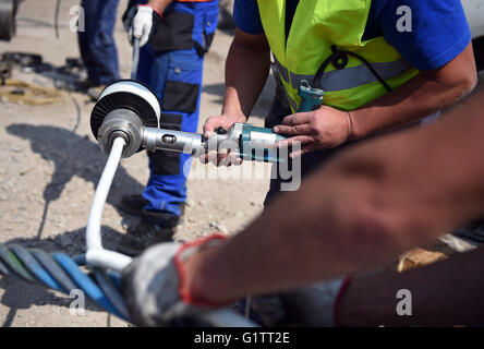 Lavoratori impiombare il filo di controllo per il cavo auto presso il cantiere per la International Garden Show (IGA) di Berlino, Germania, 18 maggio 2916. Molla di avviamento 2017, gondole di cavalcare lungo la 1.5km-lungo percorso ad una altezza di 30 metri. Foto: Britta Pedersen/dpa Foto Stock