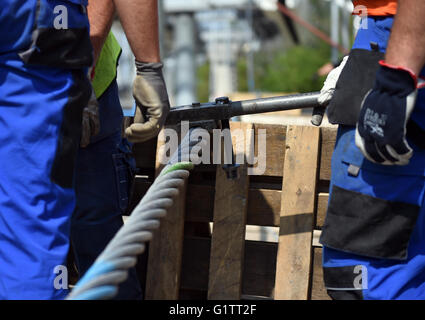 Lavoratori impiombare il filo di controllo per il cavo auto presso il cantiere per la International Garden Show (IGA) di Berlino, Germania, 18 maggio 2916. Molla di avviamento 2017, gondole di cavalcare lungo la 1.5km-lungo percorso ad una altezza di 30 metri. Foto: Britta Pedersen/dpa Foto Stock