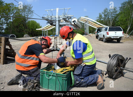 Lavoratori impiombare il filo di controllo per il cavo auto presso il cantiere per la International Garden Show (IGA) di Berlino, Germania, 18 maggio 2916. Molla di avviamento 2017, gondole di cavalcare lungo la 1.5km-lungo percorso ad una altezza di 30 metri. Foto: Britta Pedersen/dpa Foto Stock