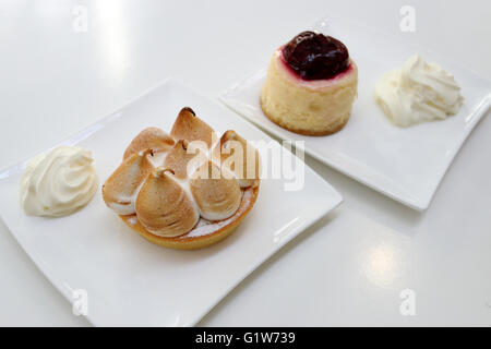 Meringa al limone e Strawberry Cheesecake su piastra bianca Foto Stock